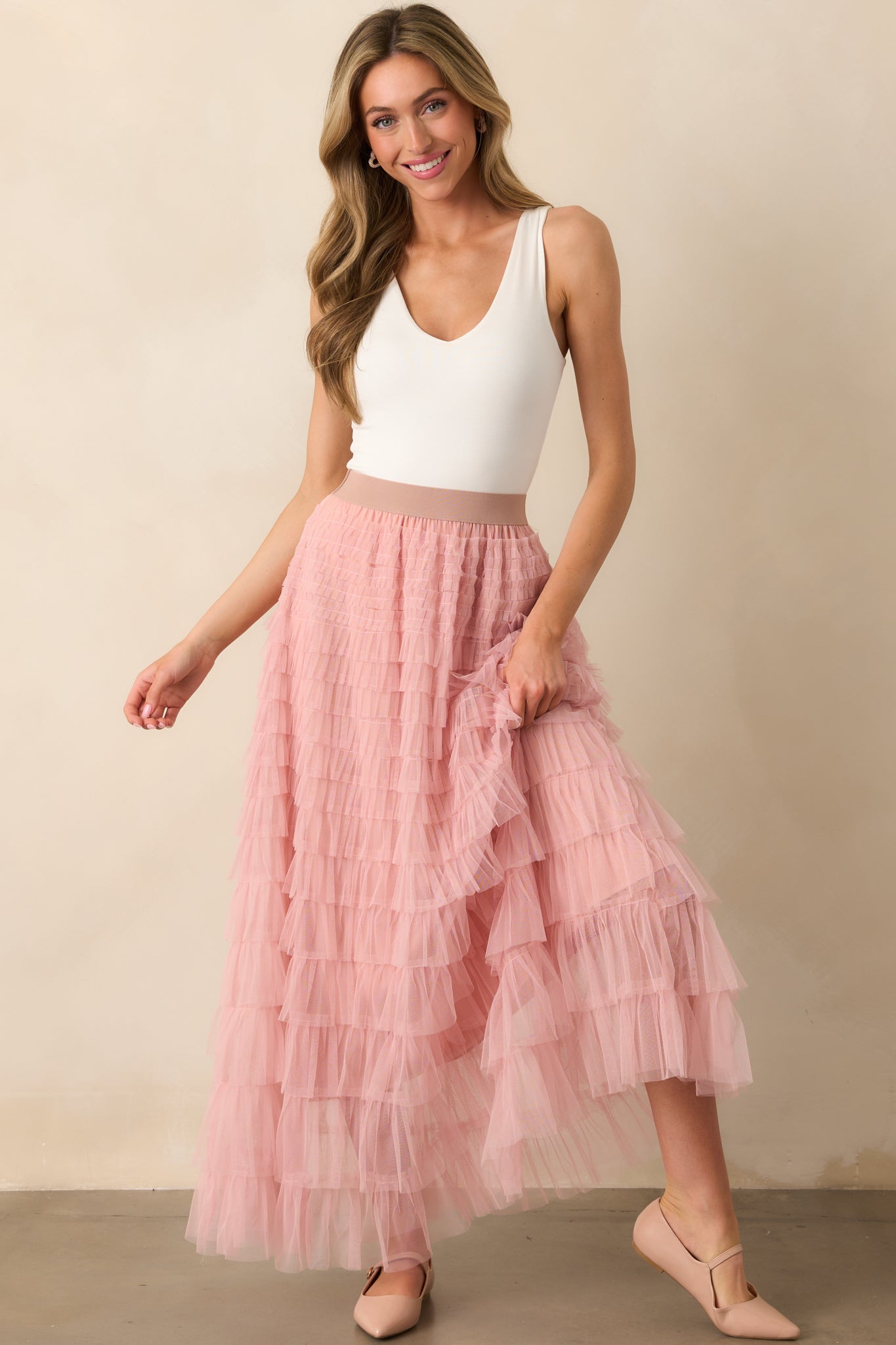 A flowing dusty pink maxi skirt with tiered tulle layers for a soft and romantic look.