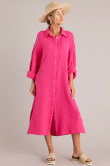 Full front view of this dress that features a collared neckline, functional buttons down the front, a front pocket on the left side of the bust, long sleeves with a cuff secured by a functional button, and two slits up the bottom hemline ending just below the knee.