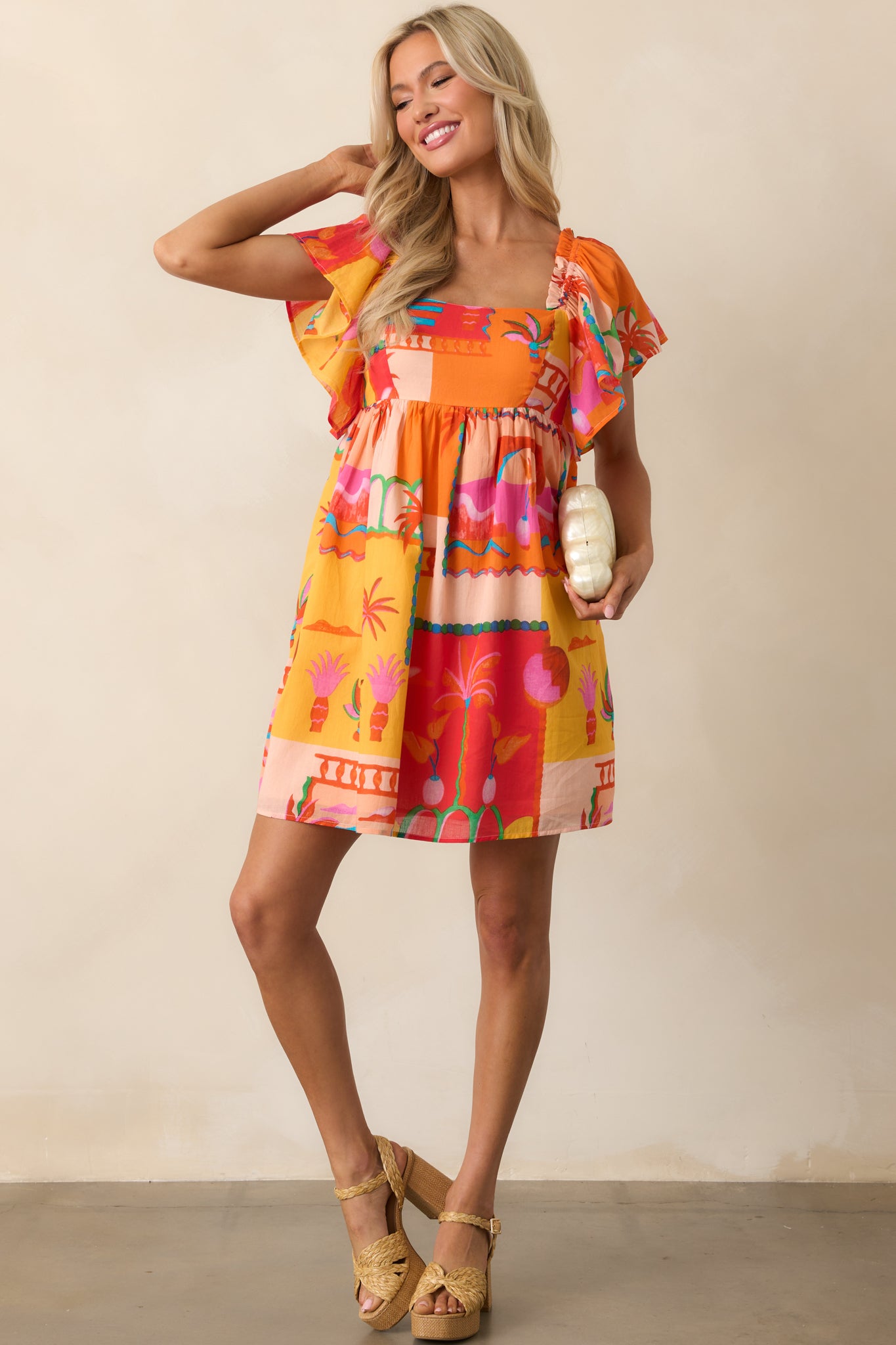 Full body image highlighting the structured square neckline and the airy flutter sleeve detail of the orange dress.