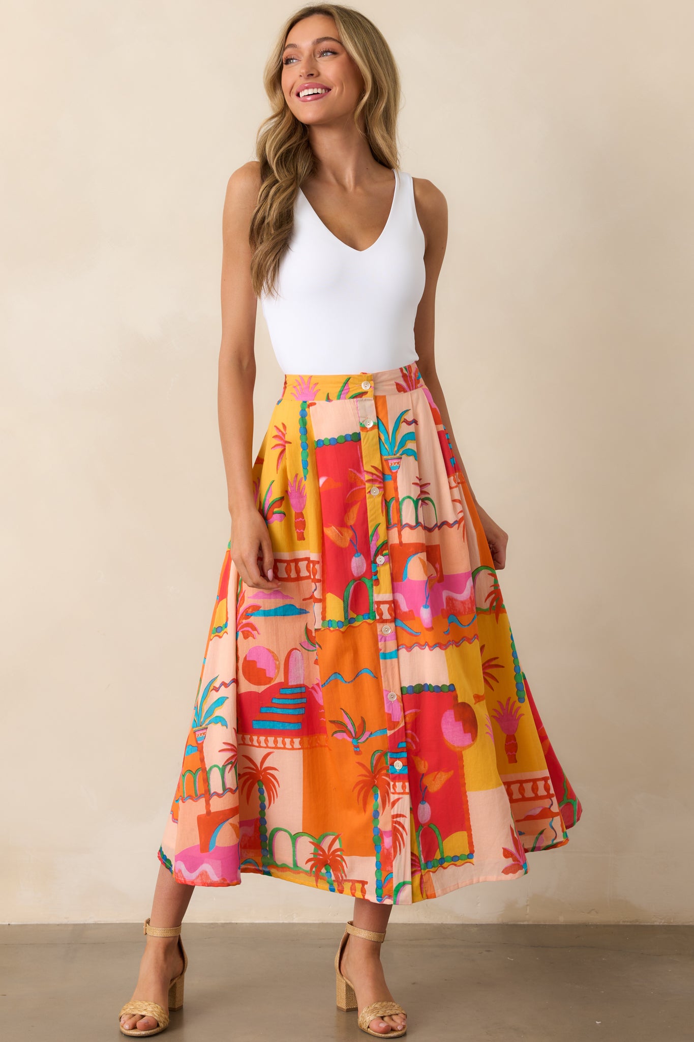 Front view of an orange skirt featuring a high waisted design, functional button front, and two side pockets.