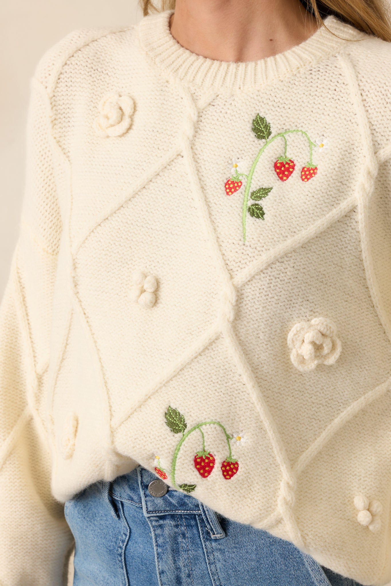 A zoomed-in view of the embroidered strawberry vine, highlighting the delicate stitching and vibrant colors.