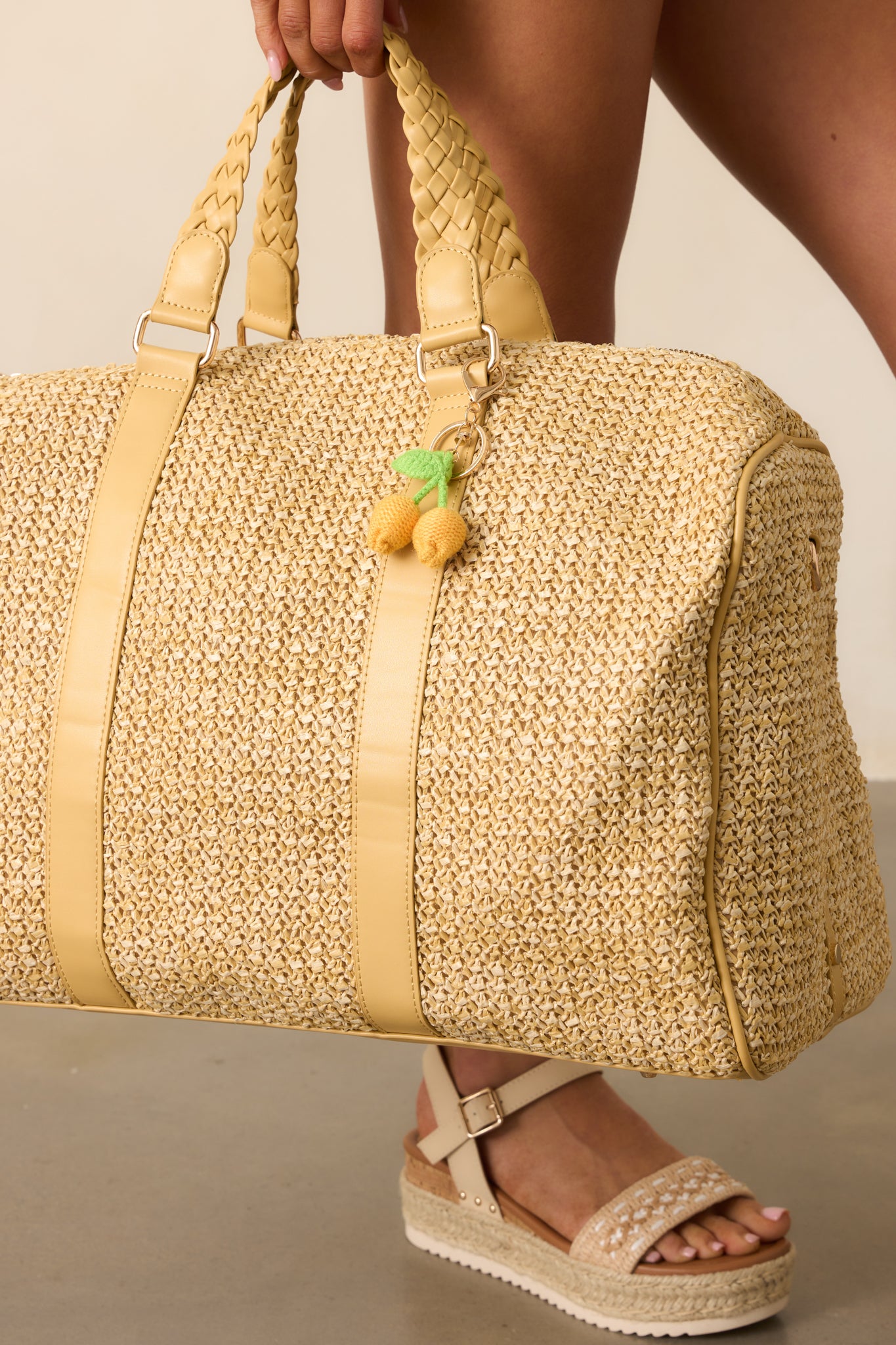 Extreme close-up of the crocheted yellow lemons and green leaves charm attached to the handle, highlighting the texture and craftsmanship.