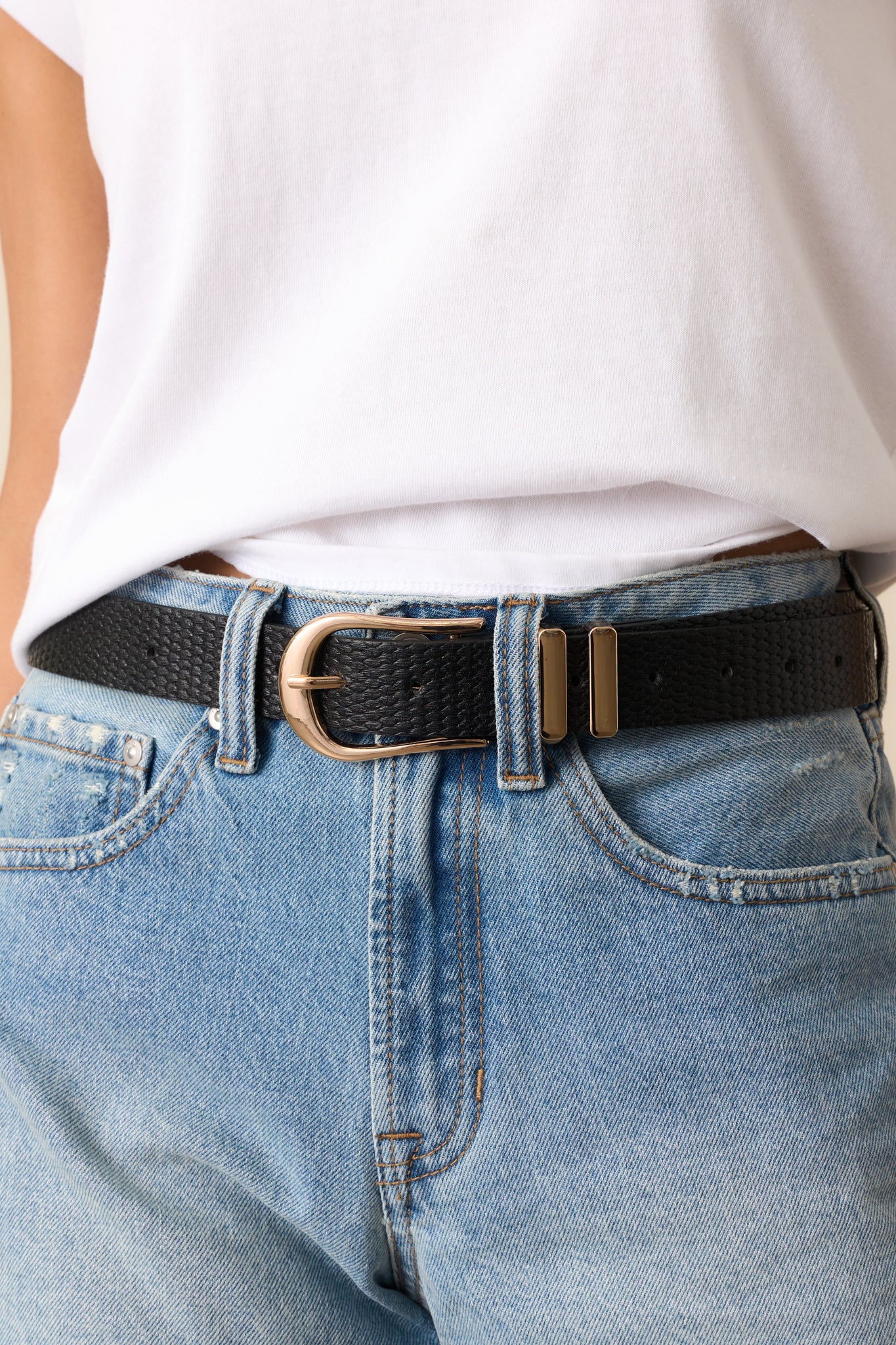 Detailed view of the woven texture and gold hardware on the black belt, emphasizing the craftsmanship.