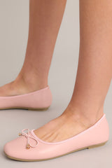 These pink flats feature a square toe, a bow detail, a matte finish, and a memory foam insole.
