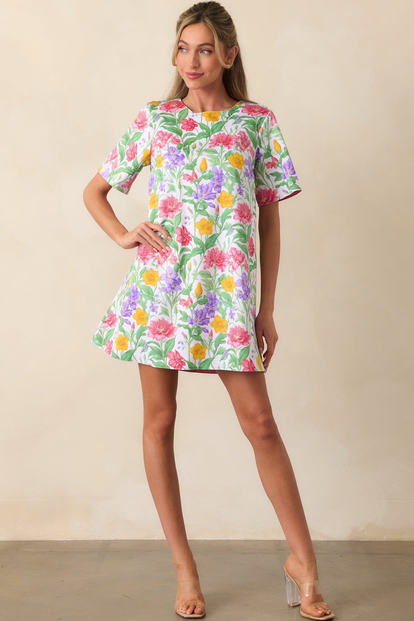 A mini dress featuring an exclusive Prosperina floral print on one side and a solid geranium pink on the other, designed with a shift silhouette.