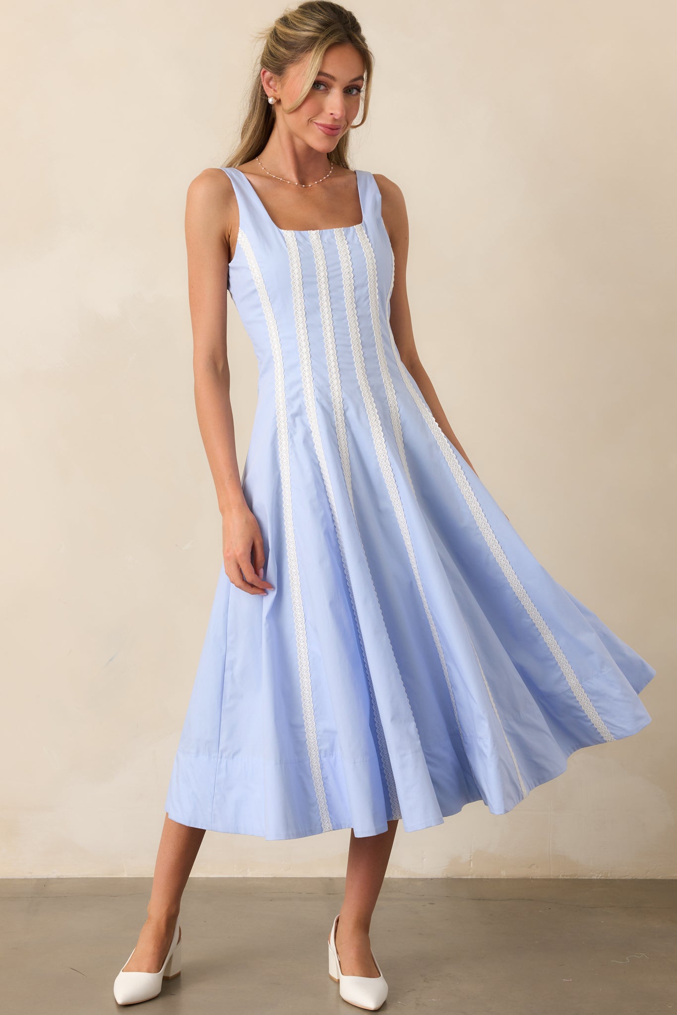 Feminine baby blue midi dress with a classic sleeveless design, softly flowing skirt, and lace stripe details.