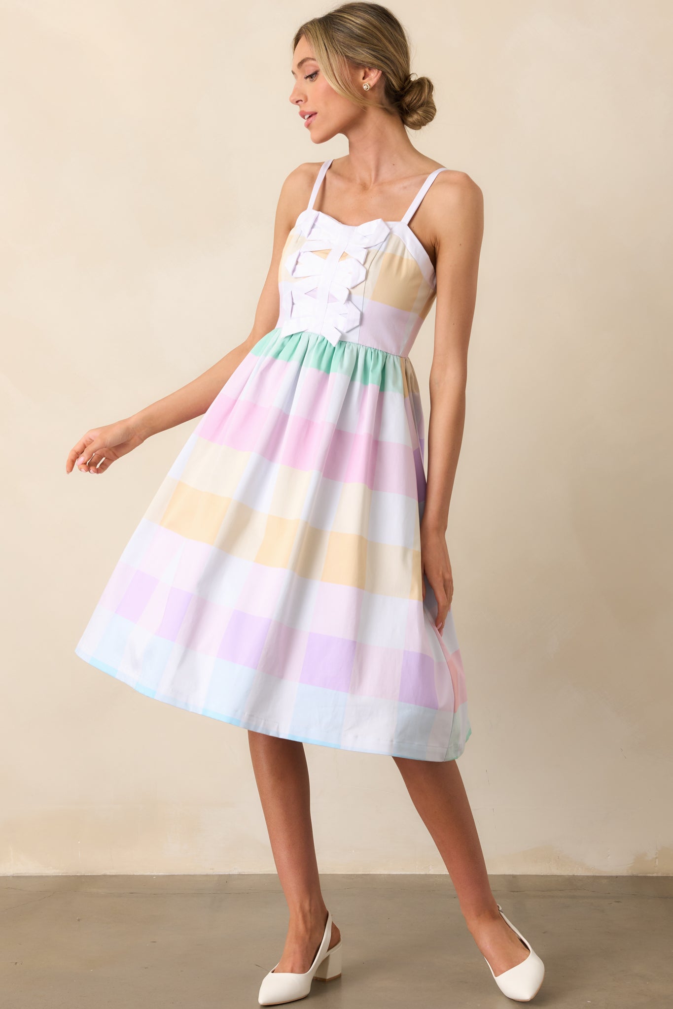 A vibrant gingham midi dress with adjustable straps, a fitted bodice, and a flowing skirt with functional pockets.