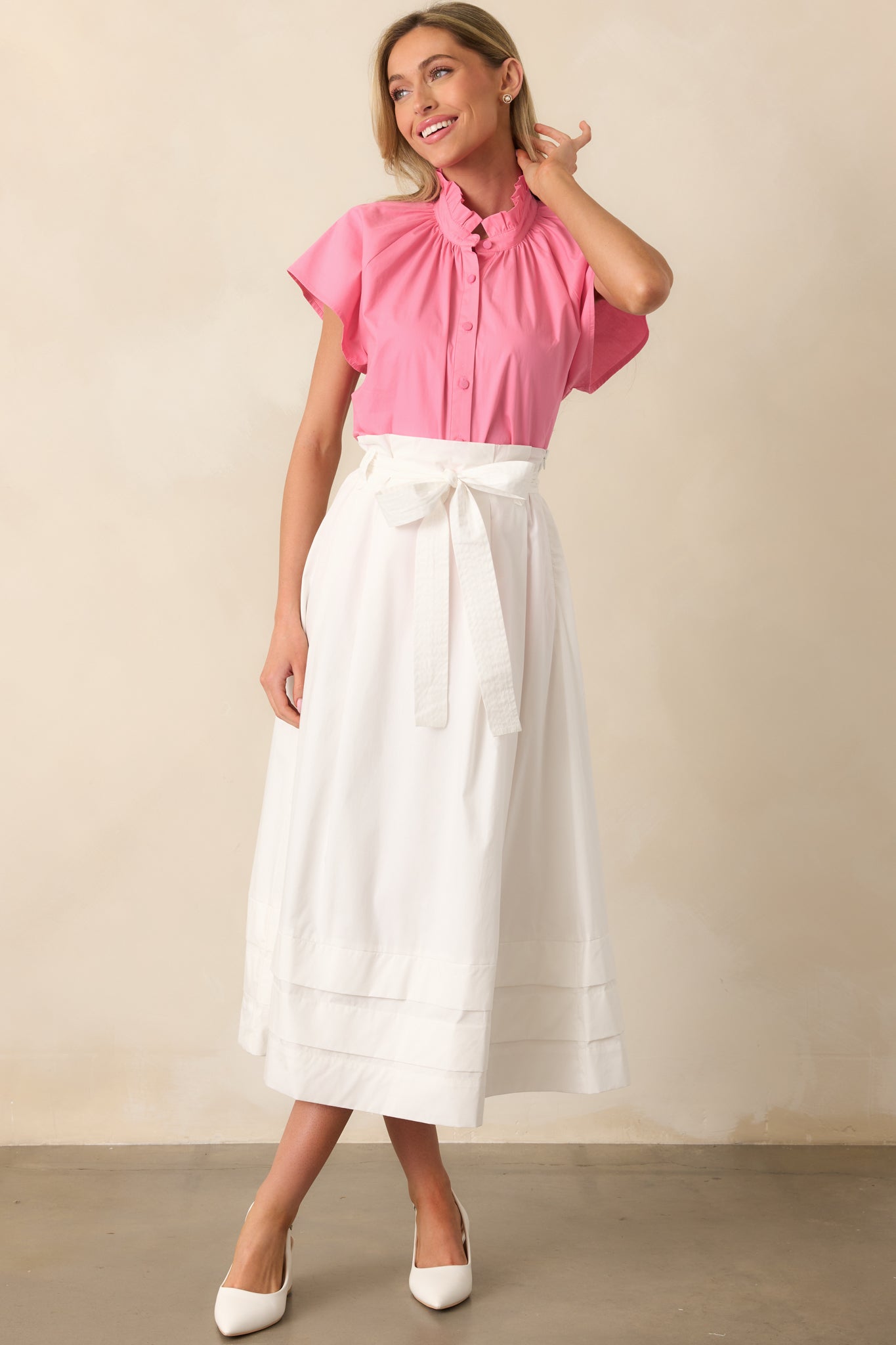 White midi skirt with pleated detailing, small tiers at the bottom, functional belt loops, and an optional self-tie belt, offering an elegant and flattering silhouette.