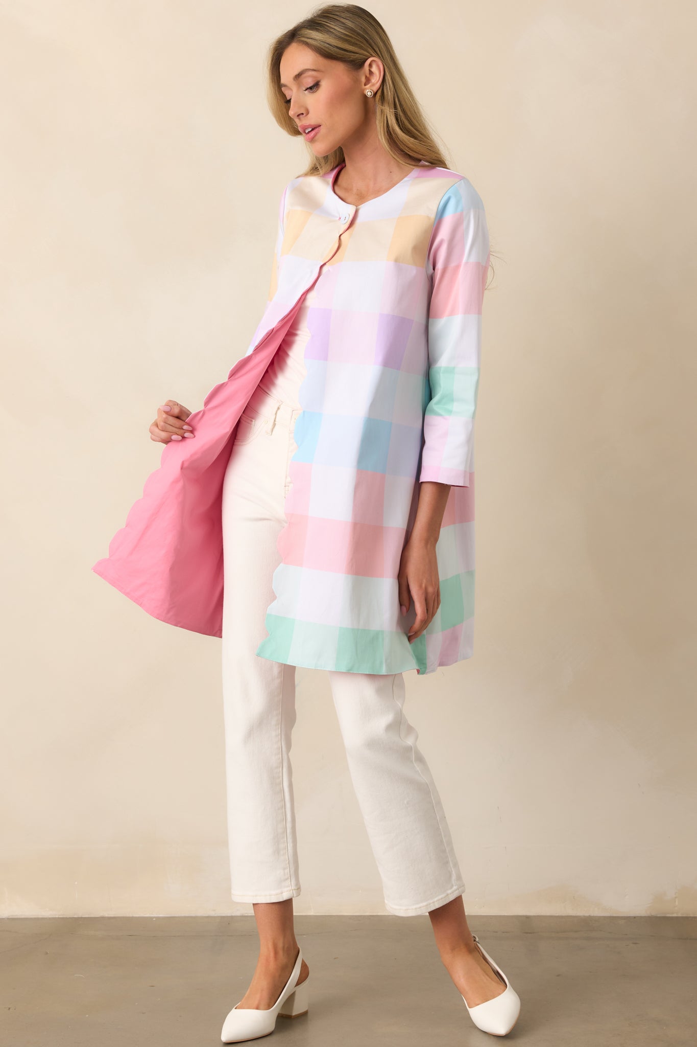 A reversible jacket with a pastel plaid print on one side, solid geranium pink on the other, and a scalloped hem for a delicate touch.