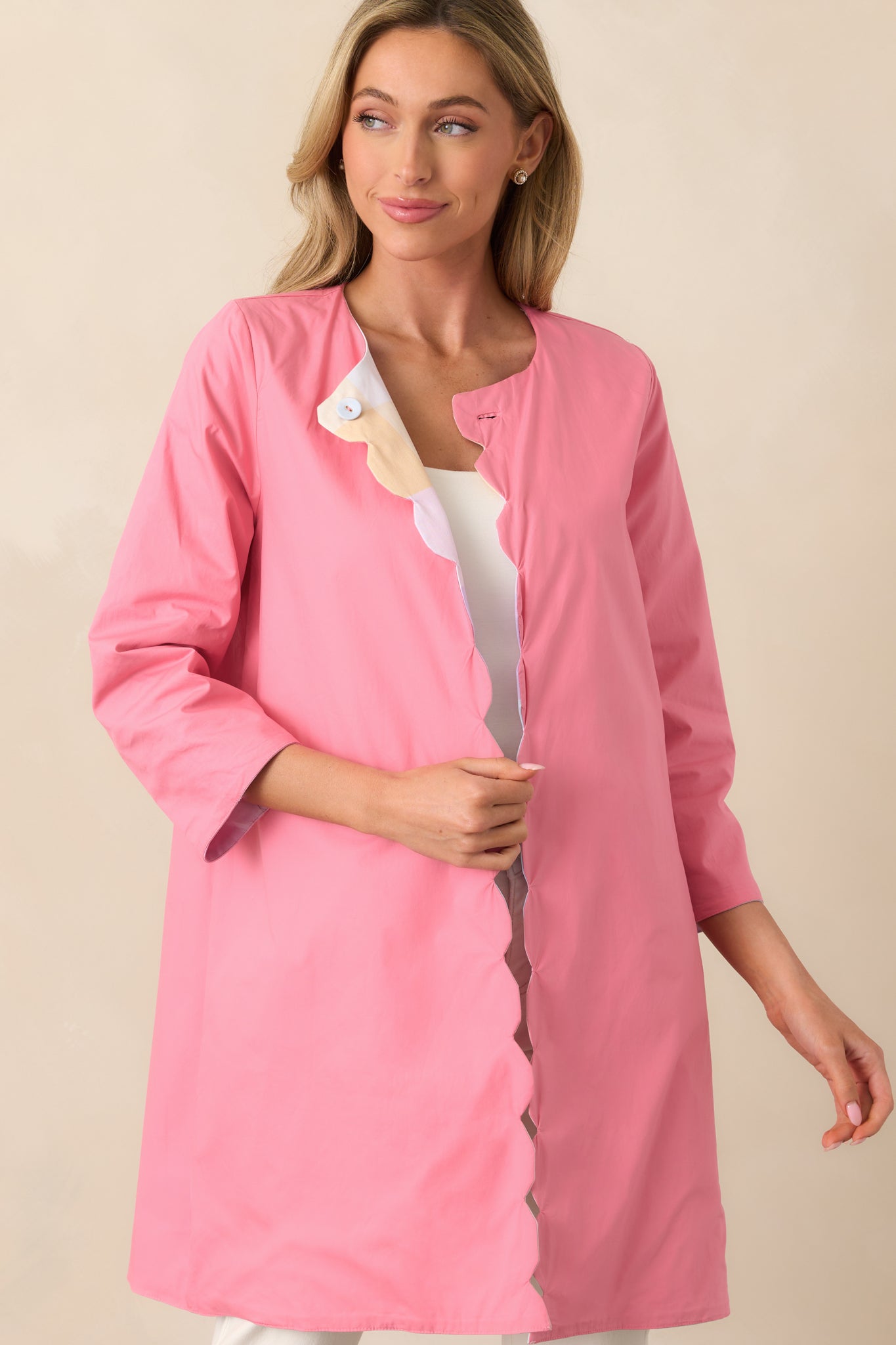 A close-up of the scalloped hem on the solid geranium pink side, highlighting the smooth fabric and structured finish.