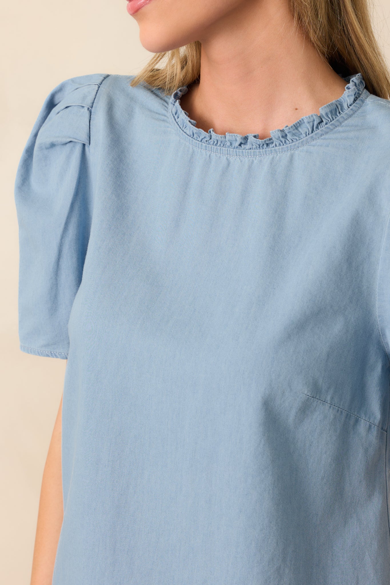 A zoomed-in look at the back keyhole button closure, showing the fine pleated detailing and ruffled trim.