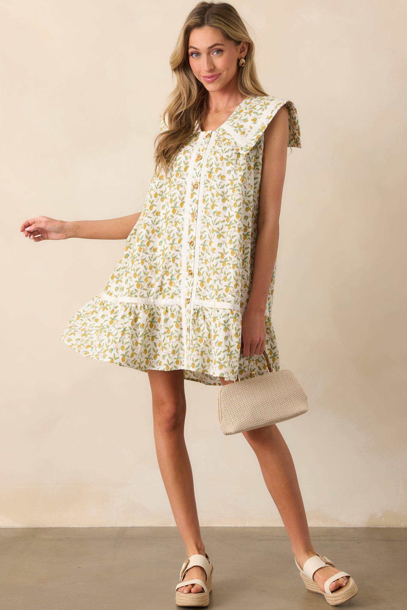 Front-facing image of a lemon-printed mini dress highlighting the functional pockets and flared hemline.