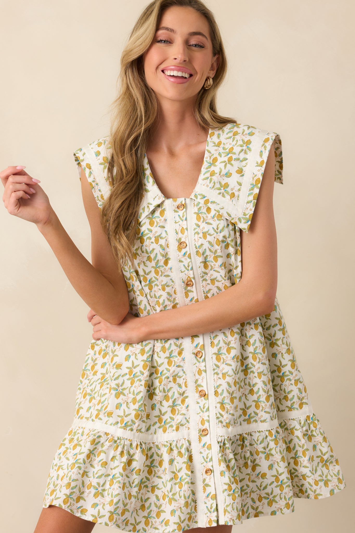 Cropped view focusing on the sailor-style collar with ivory ribbon trim on the lemon print mini dress.