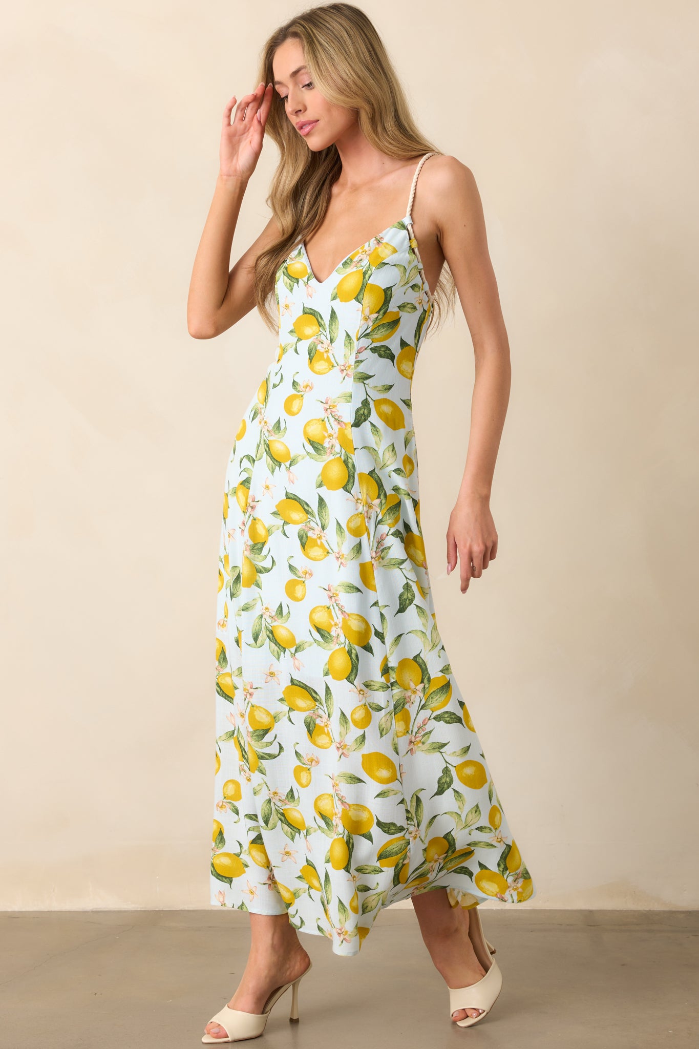 Full body view of light blue dress with yellow and green lemon print, v-neckline, and crisscross rope-inspired straps.