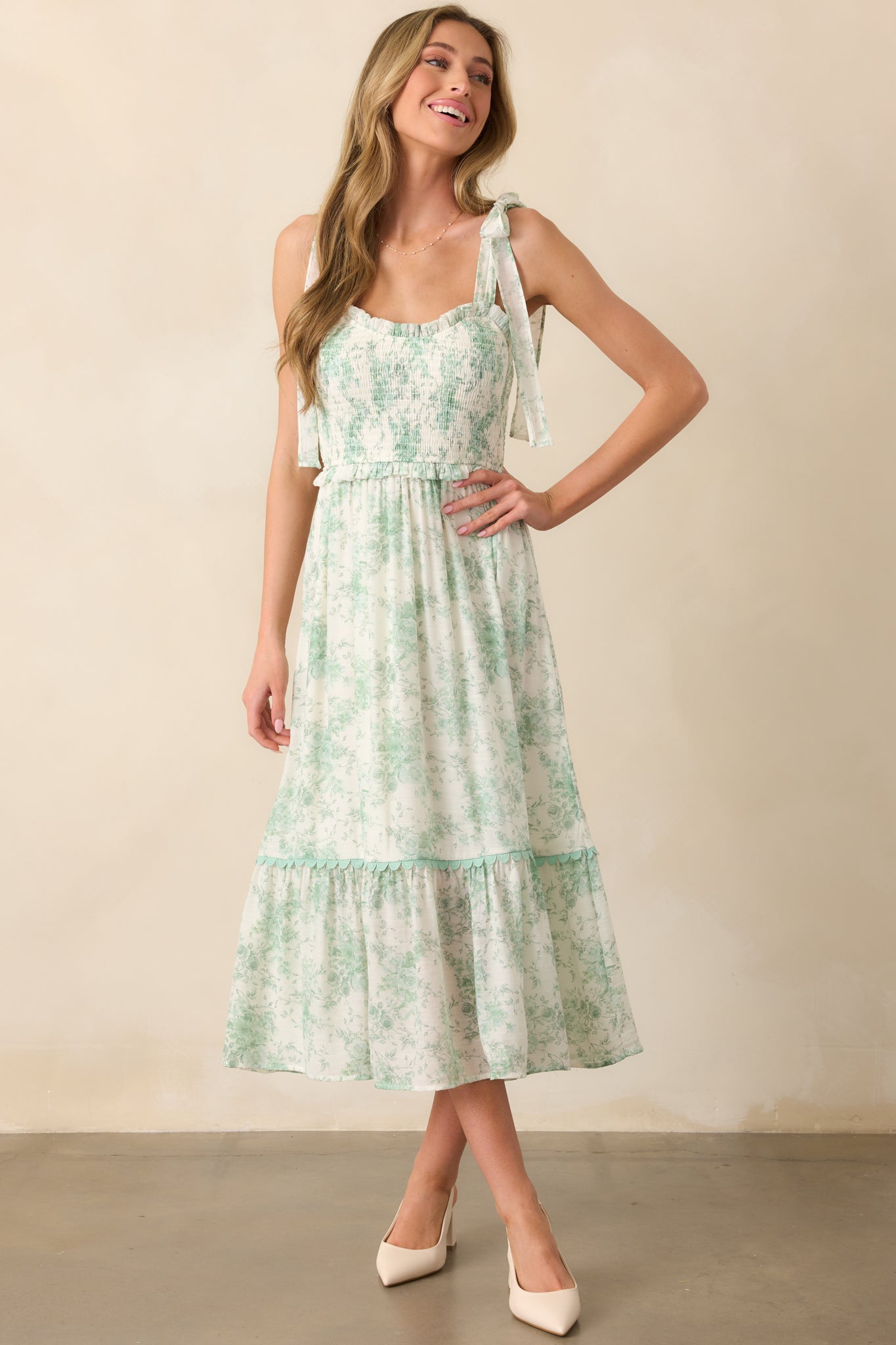 Full-body image highlighting the smocked bodice, floral toile print, and tiered skirt with ric rac trim.