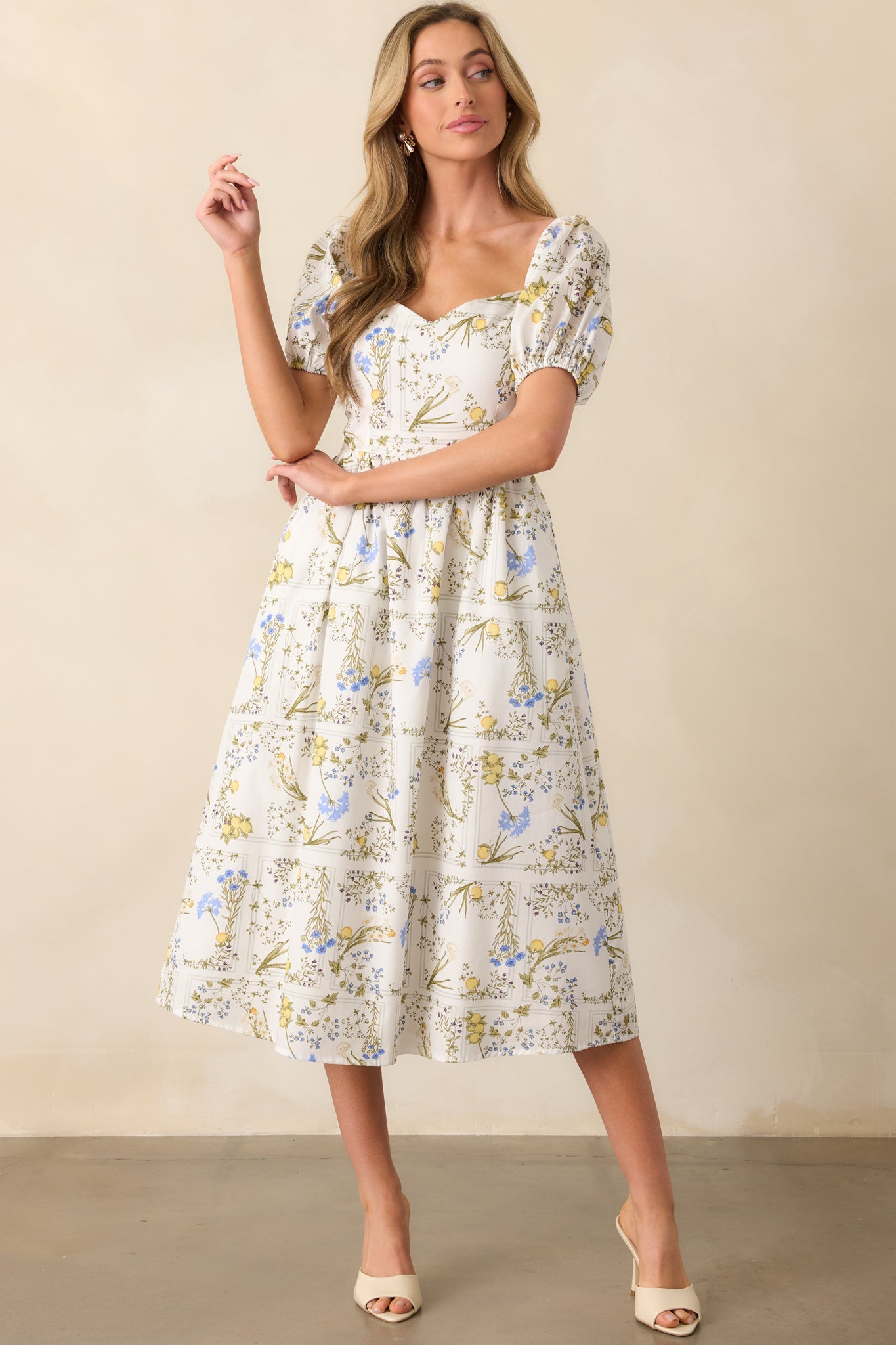 White midi dress with yellow and blue lemon floral print, shown front-facing with visible sweetheart neckline and short puff sleeves.