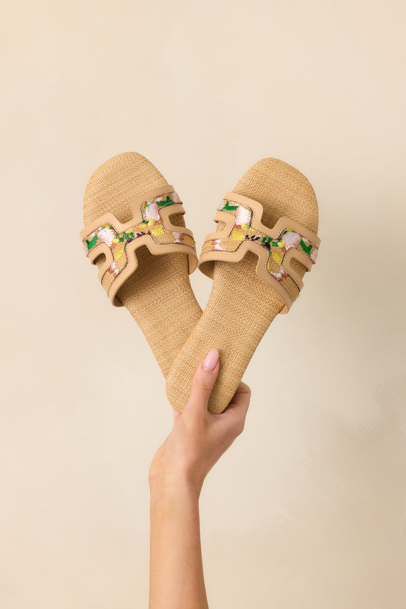 Raffia slide sandals with H-shaped vamp straps and multicolor floral embroidery across the front.