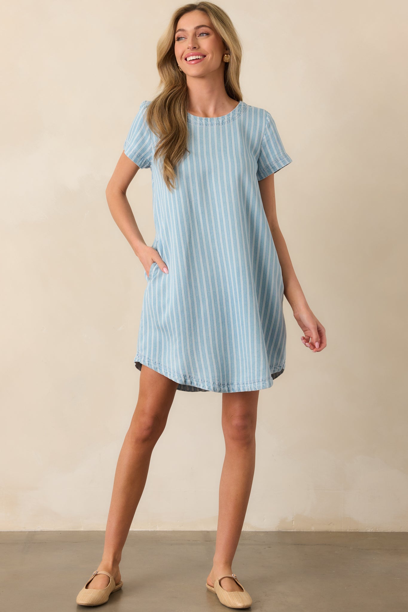 Mini dress with round neckline, cuffed short sleeves, and scoop hemline shown in a relaxed silhouette.