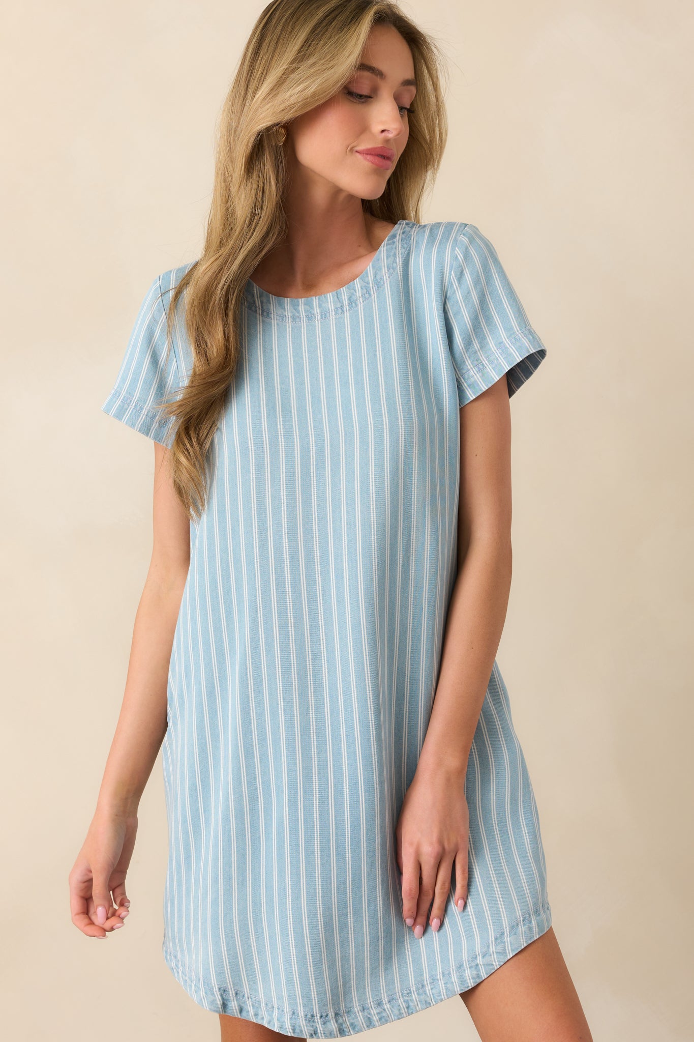 Close-up of round neckline and cuffed short sleeves on the mini dress, emphasizing stitching and shape.