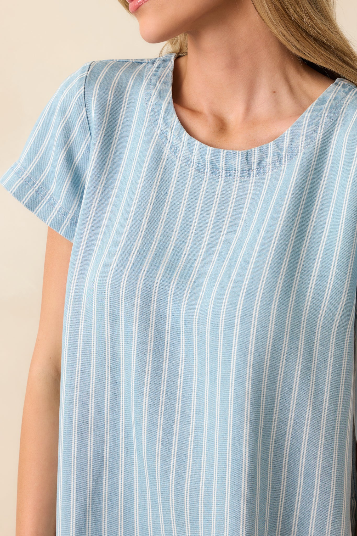 Macro shot of the faux button detailing at the upper back of the mini dress, including two functional top buttons.