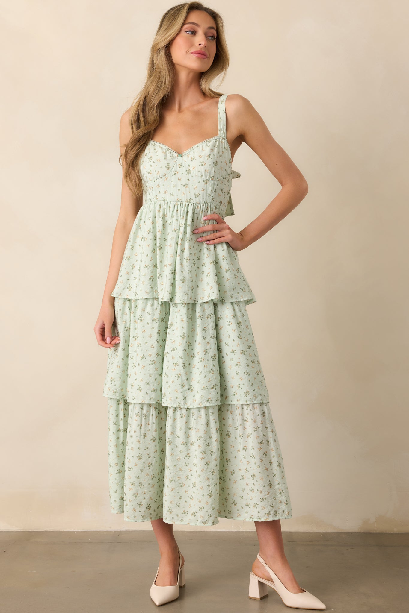 A full-body shot of the mint floral maxi dress, showing the smocked back panel, two back bow details, and a flowing tiered skirt. The elastic sweetheart neckline and adjustable straps provide a flattering fit