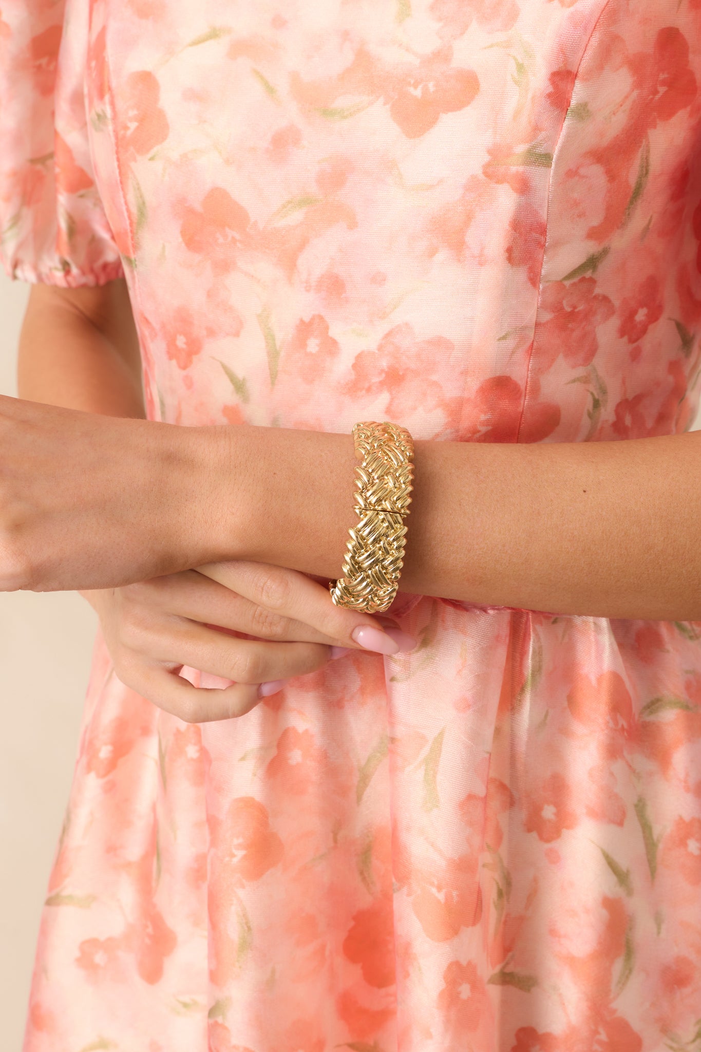Cropped image of textured gold bracelet with a woven-like design, showing the elastic bands for easy slip-on wear.