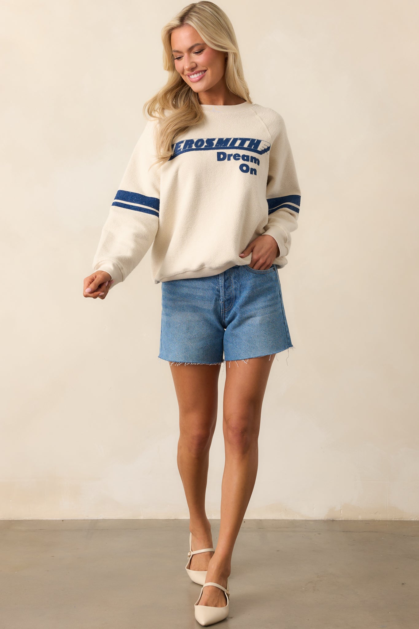 Full body shot highlighting the blue double stripe sleeves, ribbed hem, and textured ivory fabric.