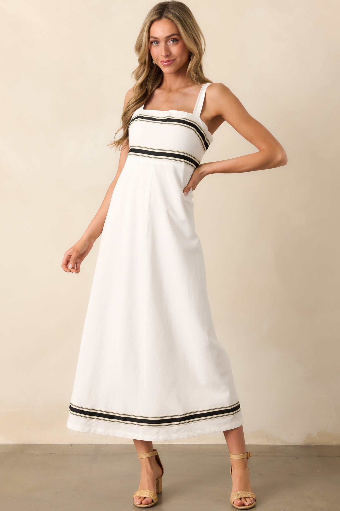 White midi dress with clean, minimal design and black contrast trim, paired with adjustable straps for a perfect fit.