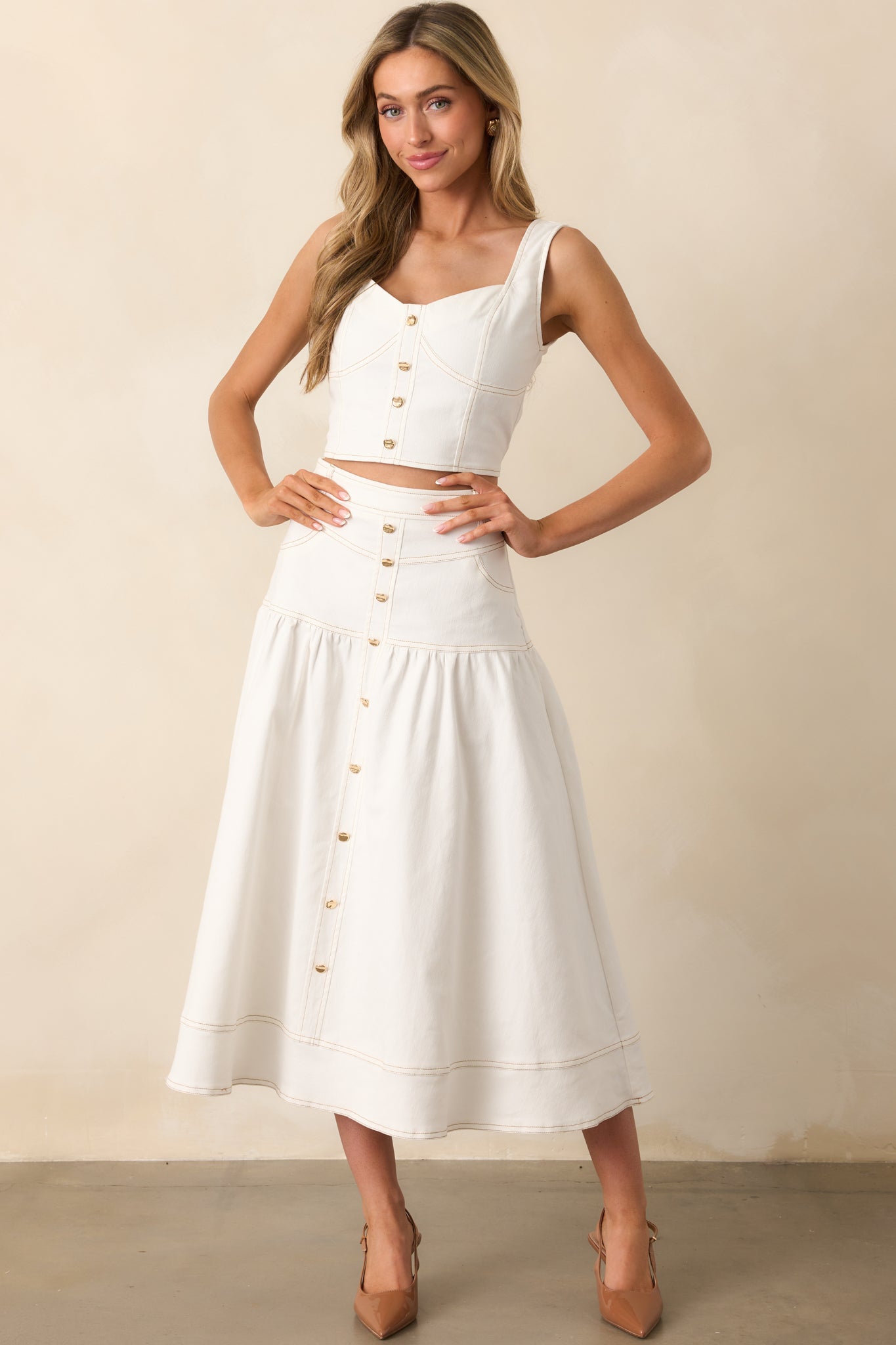 A fitted white denim top with a bold cropped cut and refined contrast stitching details.