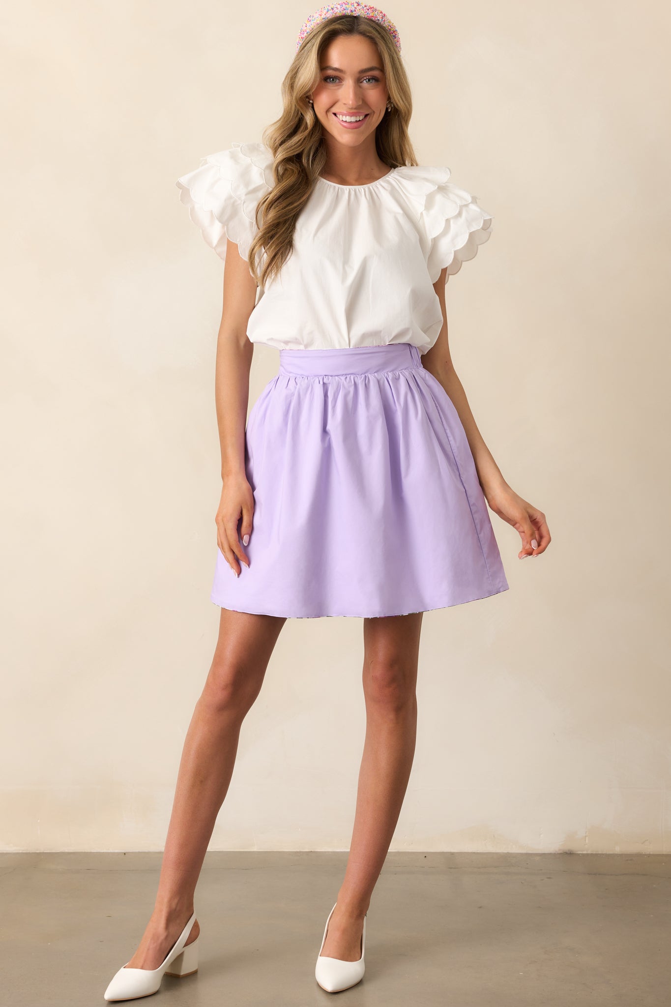 The soft lilac side of this reversible mini skirt offers a sleek and versatile look, complete with belt loops and a flattering high-waisted fit.