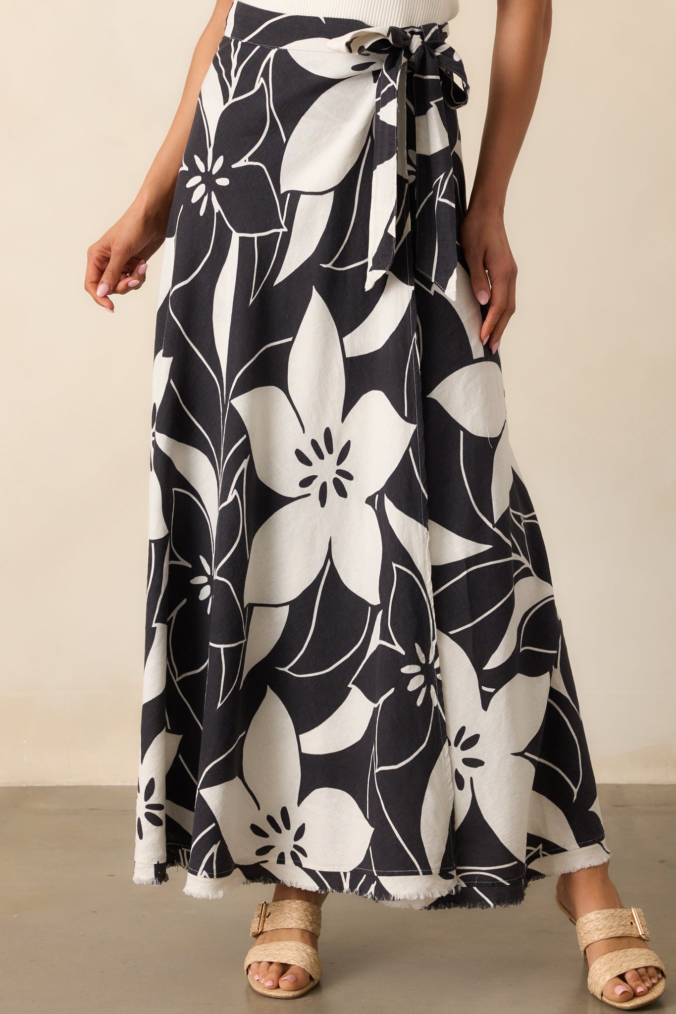 Close-up of the self-tie wrap waist of the maxi skirt, showing the adjustable tie and smooth linen blend texture.