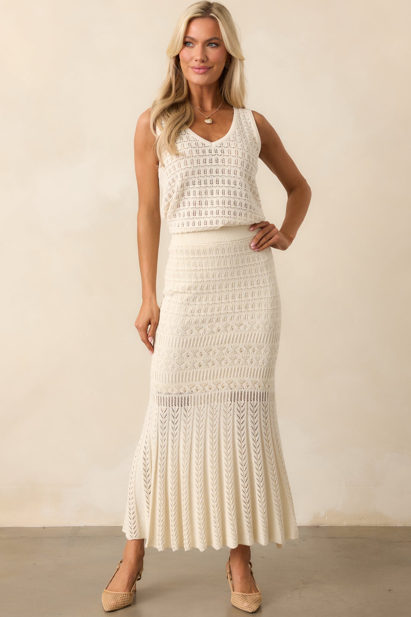 Beige crochet midi skirt with an elastic waistband, a body-hugging fit, and an open crochet overlay with a mini lining underneath.