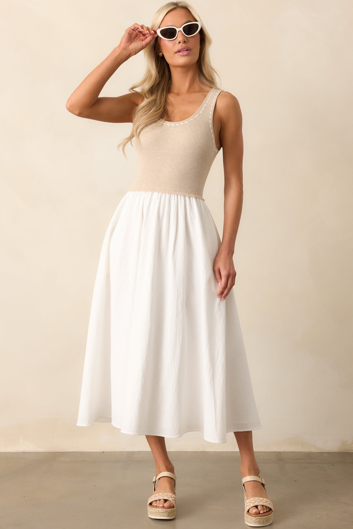 White midi dress with a scoop neckline and ribbed knit tank top-style bodice, accented by ivory blanket stitch detailing and a white skirt with pockets.