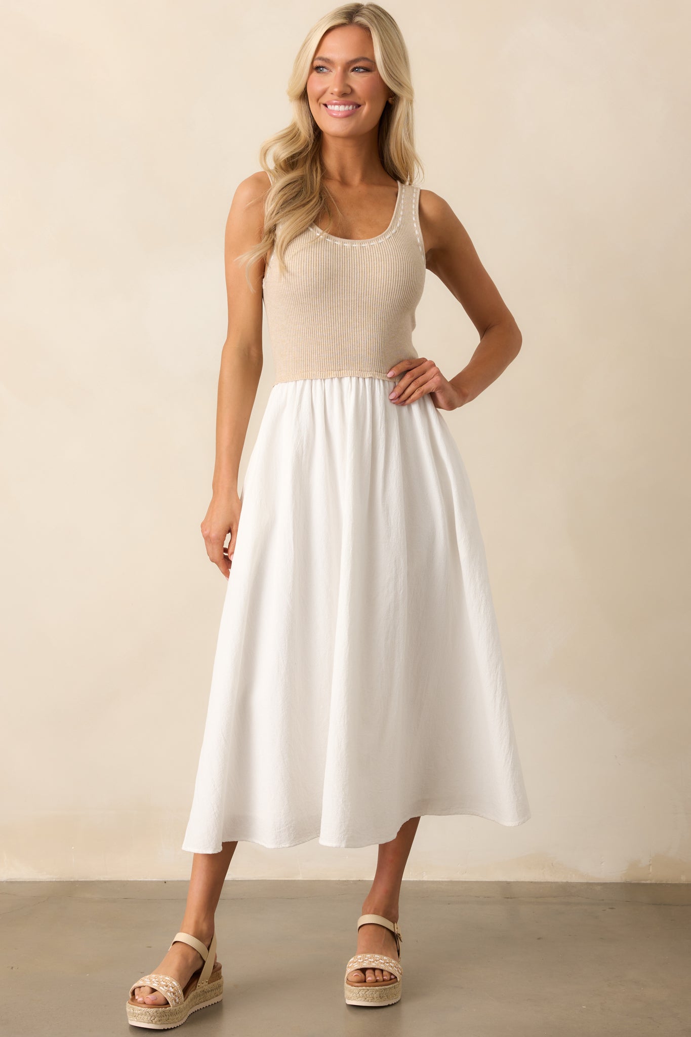 Tank top-style ribbed knit bodice with ivory blanket stitch detailing and a white midi-length skirt featuring functional pockets for a relaxed look.