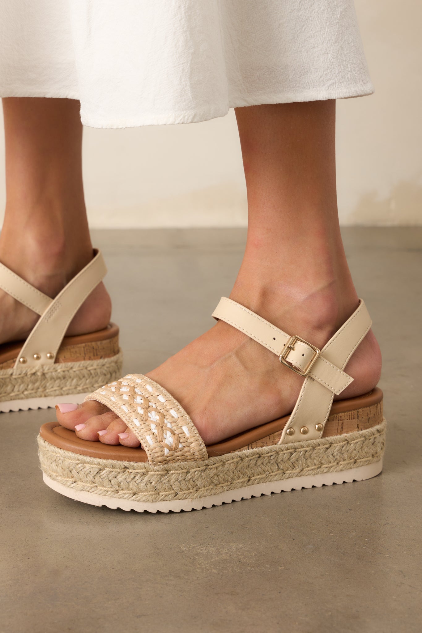 Angled cropped shot focusing on the heel area, featuring the faux leather heel strap and natural cork wedge design.