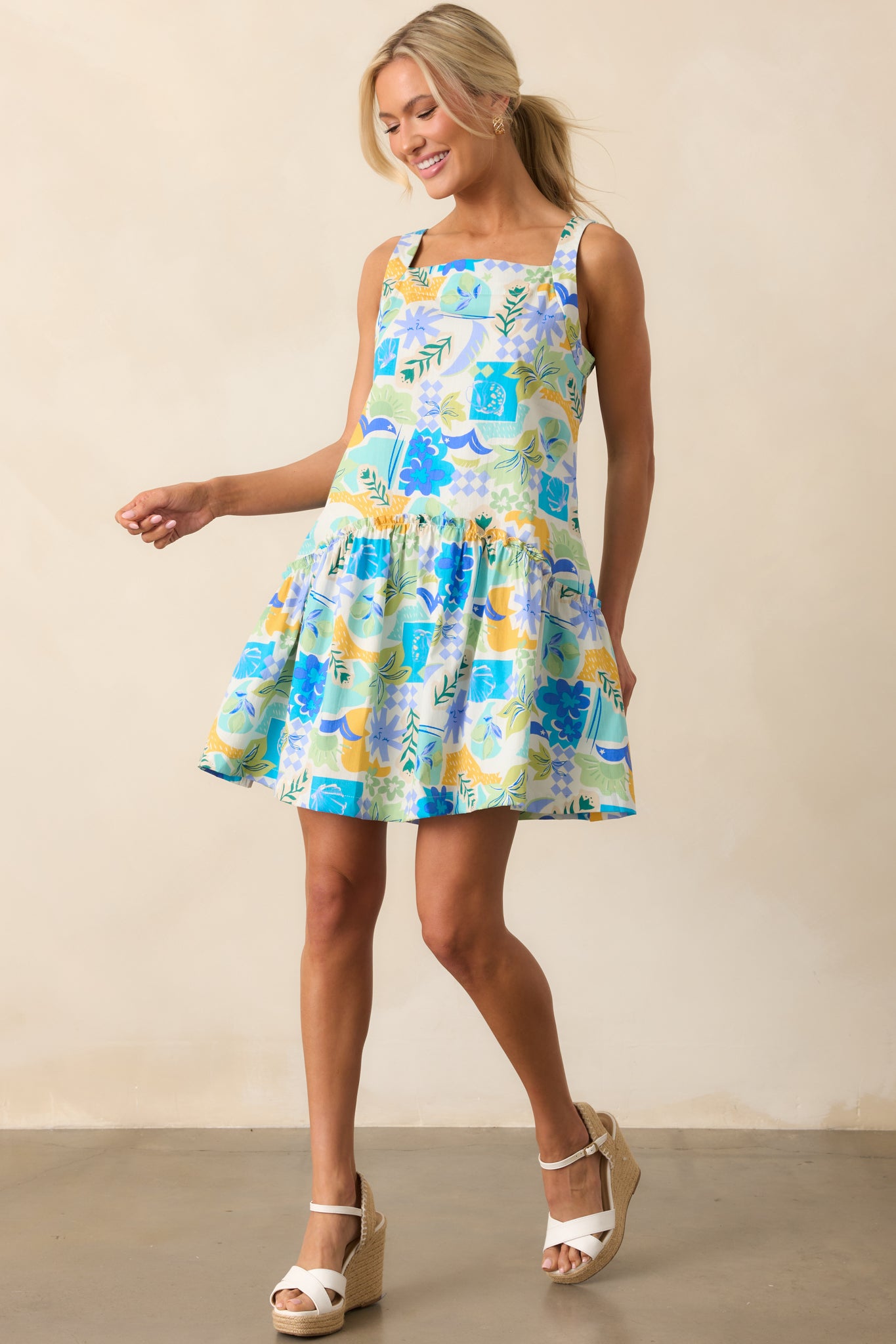 Playful and bold, this tropical print mini dress showcases a relaxed drop waist, functional pockets, and delicate ruffle details.