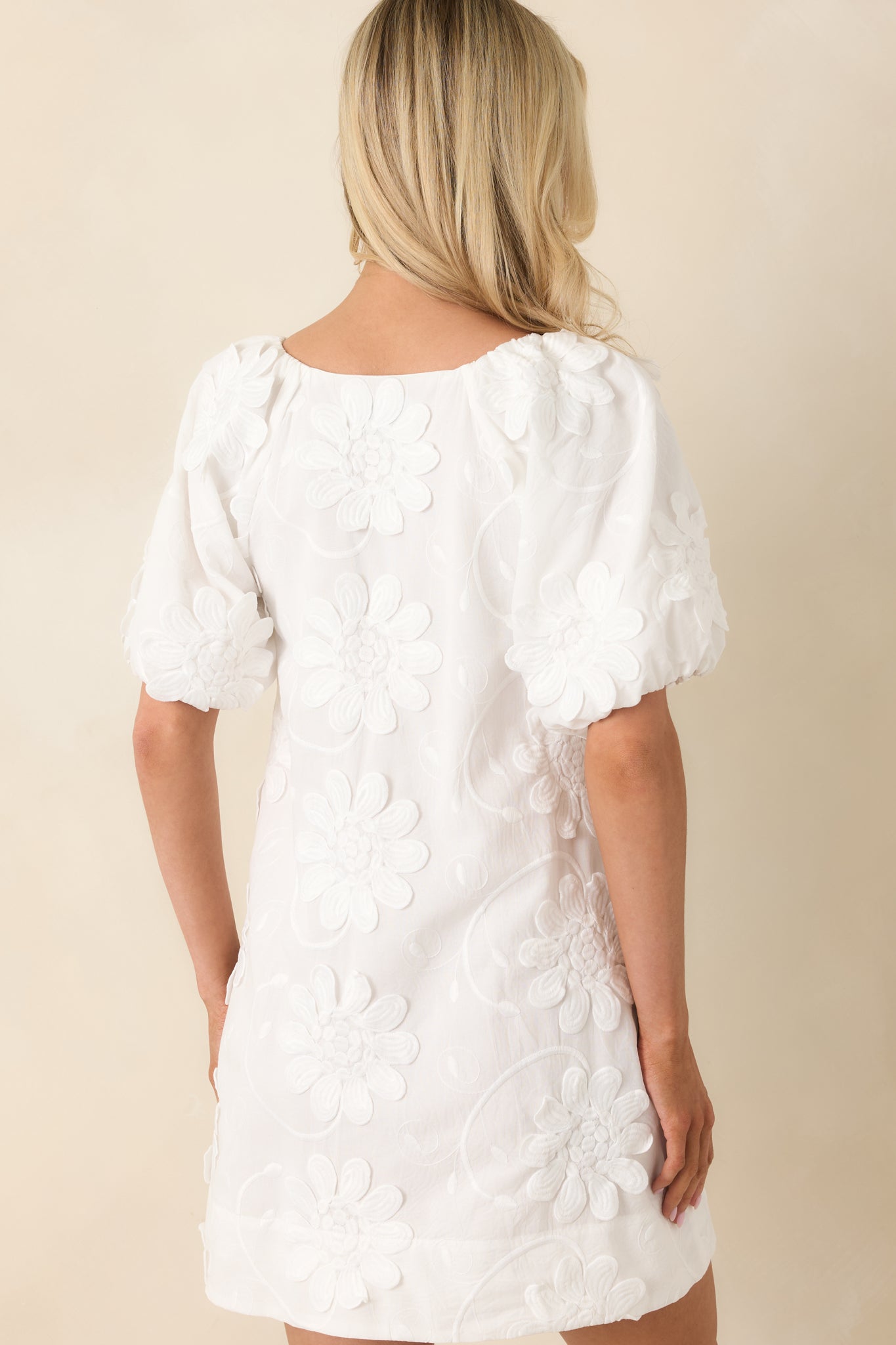 Back view of mini dress showcasing relaxed smock fit, puff sleeves, and smooth cotton construction.
