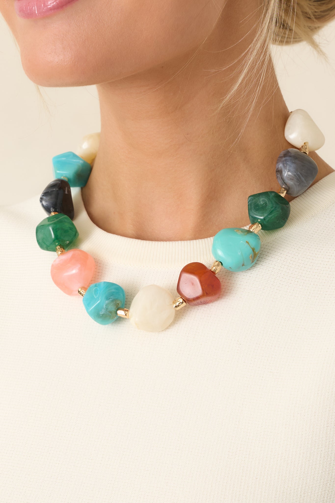Detailed close-up of multi-colored necklace highlighting faceted stone shapes, gold accent separators, and secure chain construction.