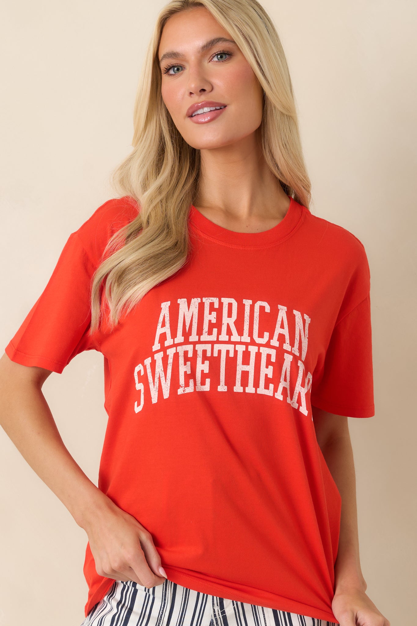 Soft red cotton top with a casual oversized fit and distressed lettering across the front.