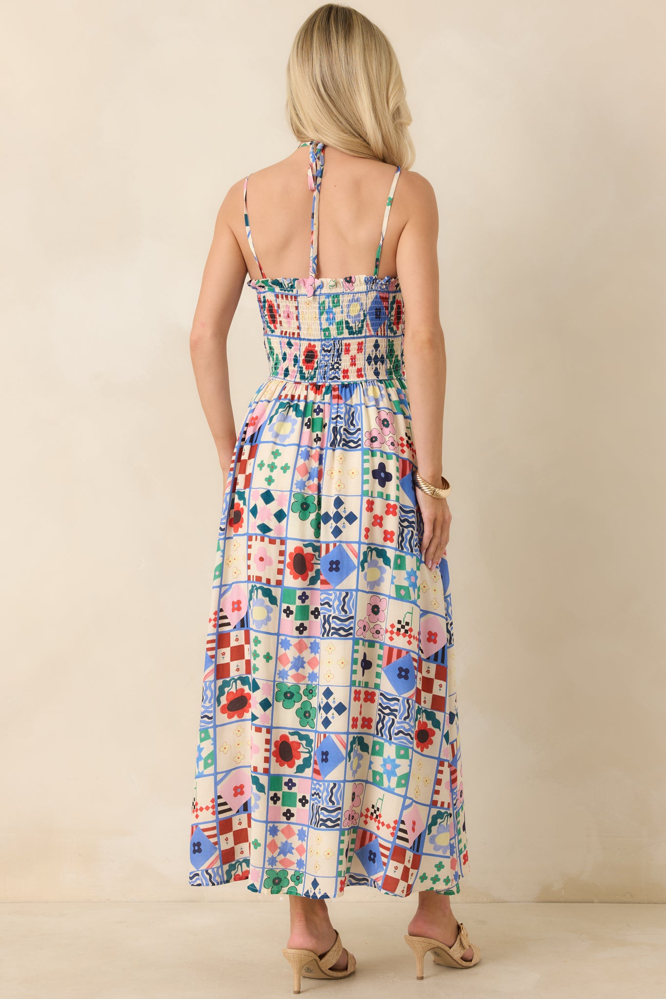 Rear view of maxi dress with smocked back panel and adjustable tie strap design.