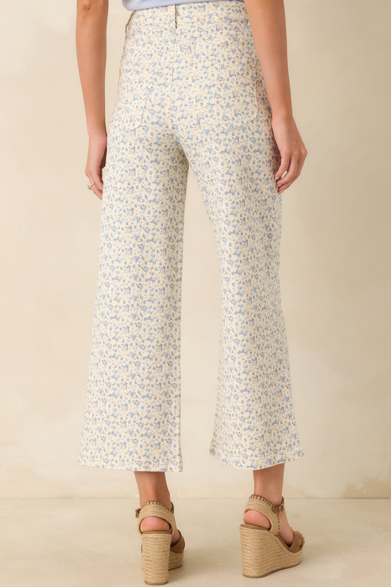 Back view of the light blue floral jeans featuring functional back pockets, straight wide-leg silhouette, and continuous floral print.