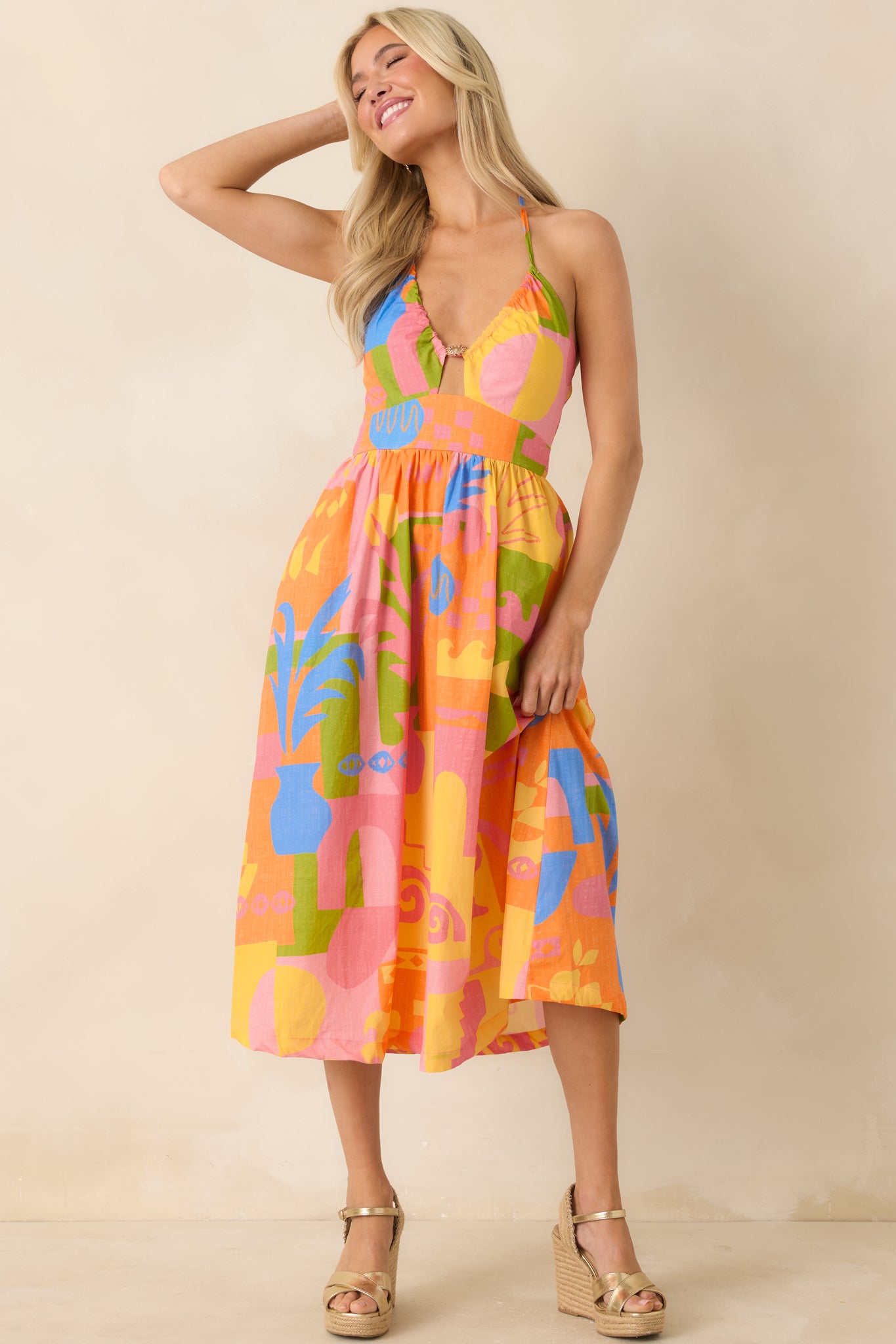 Bold abstract print midi dress with halter design and flattering structured top.