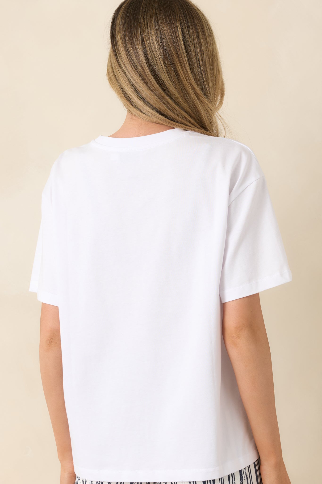 Rear view of relaxed-fit white tee with smooth cotton fabric and oversized shape.
