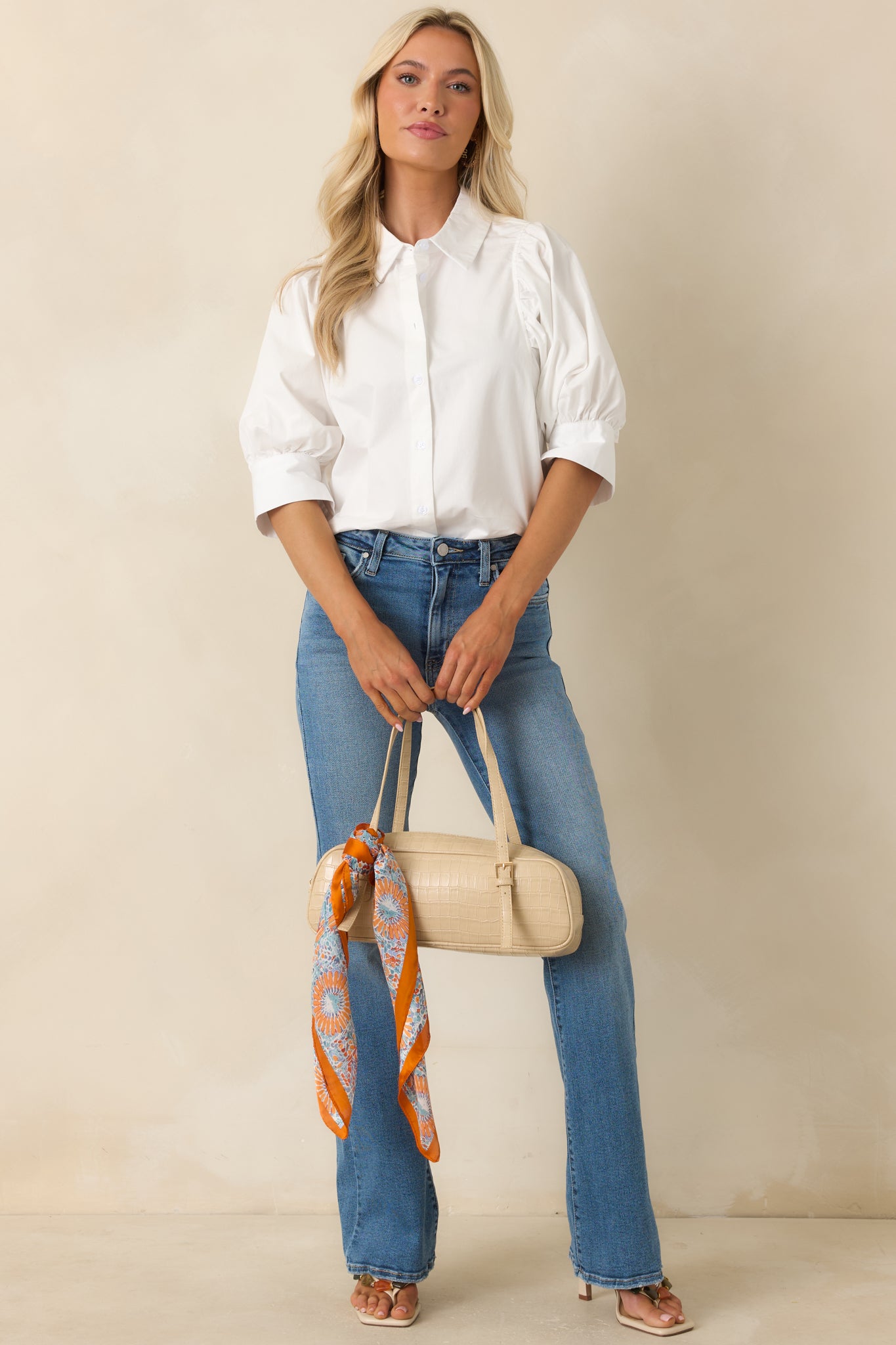 White collared cotton top showcasing a breezy silhouette, front button closures, and softly gathered sleeve details.
