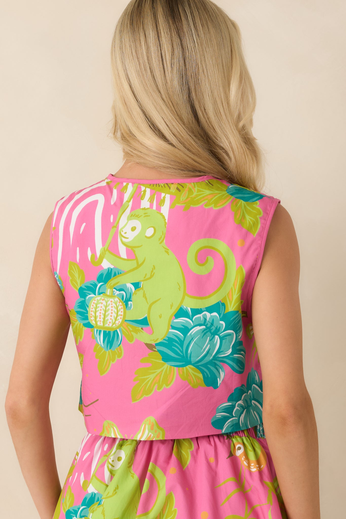 Rear view of the pink cotton top featuring a sleeveless cut, cropped length, and smooth lightweight finish.