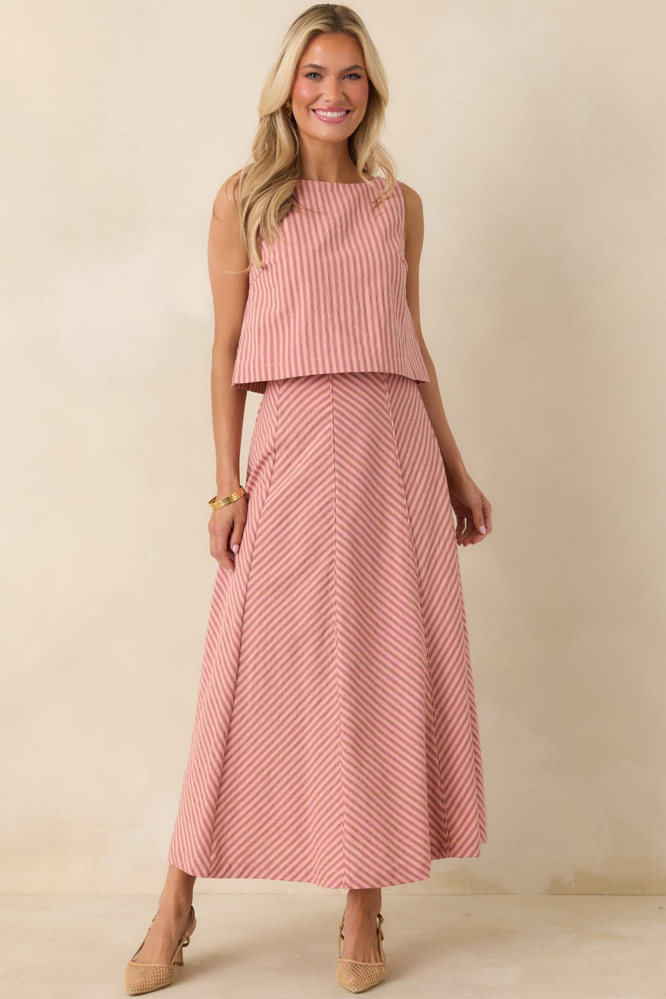Front-facing coral pink stripe top with a simple, sleeveless cut and relaxed fit in a breathable fabric blend.