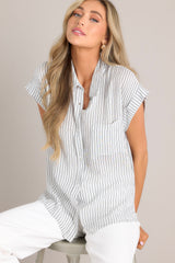 This charcoal stripe top features a collared neckline, a full button front, a functional breast pocket, and a split hemline.