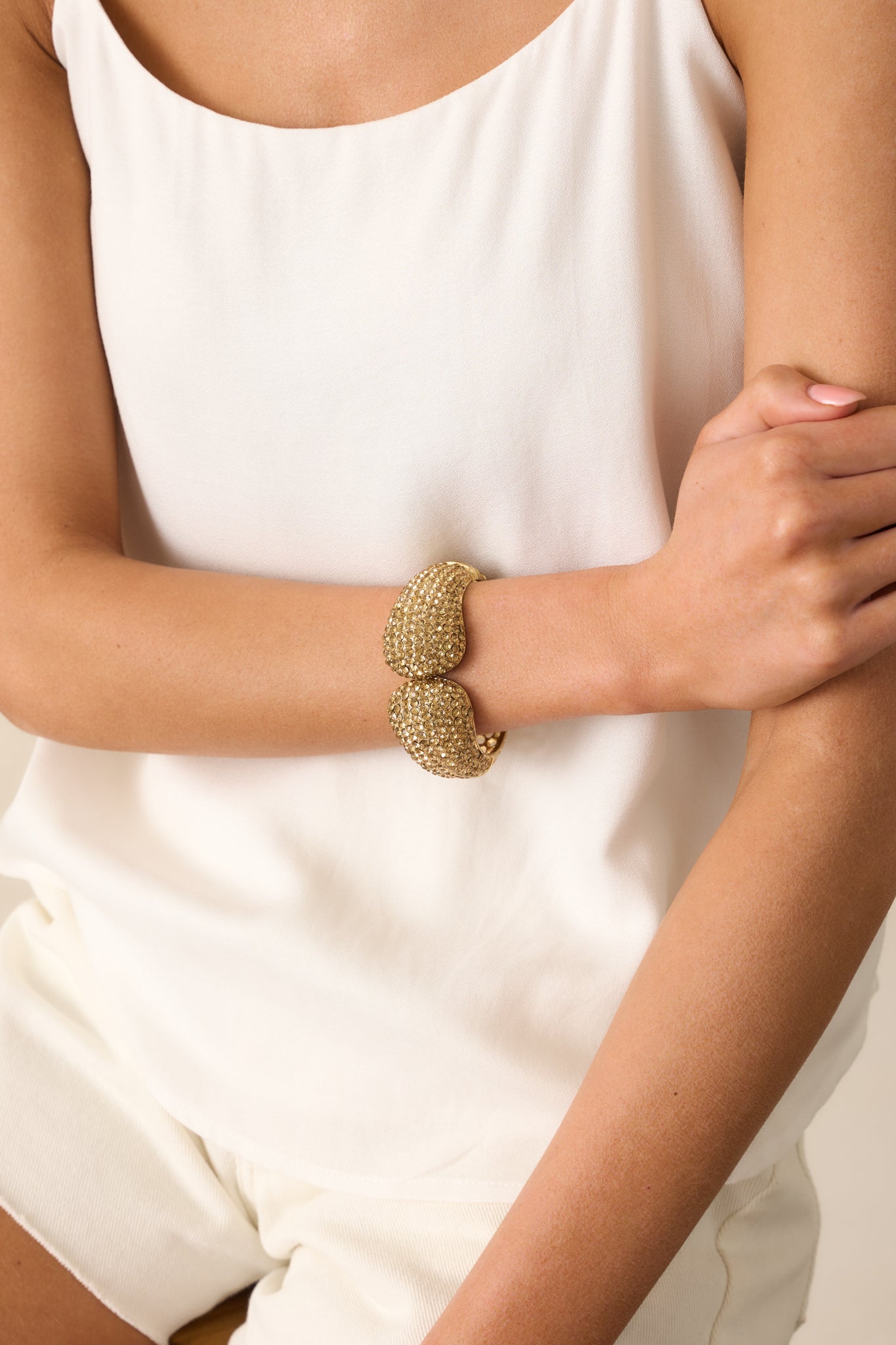 Tightly framed image focusing on the bottom half of the bracelet, highlighting the circular vent openings and curved gold surface.