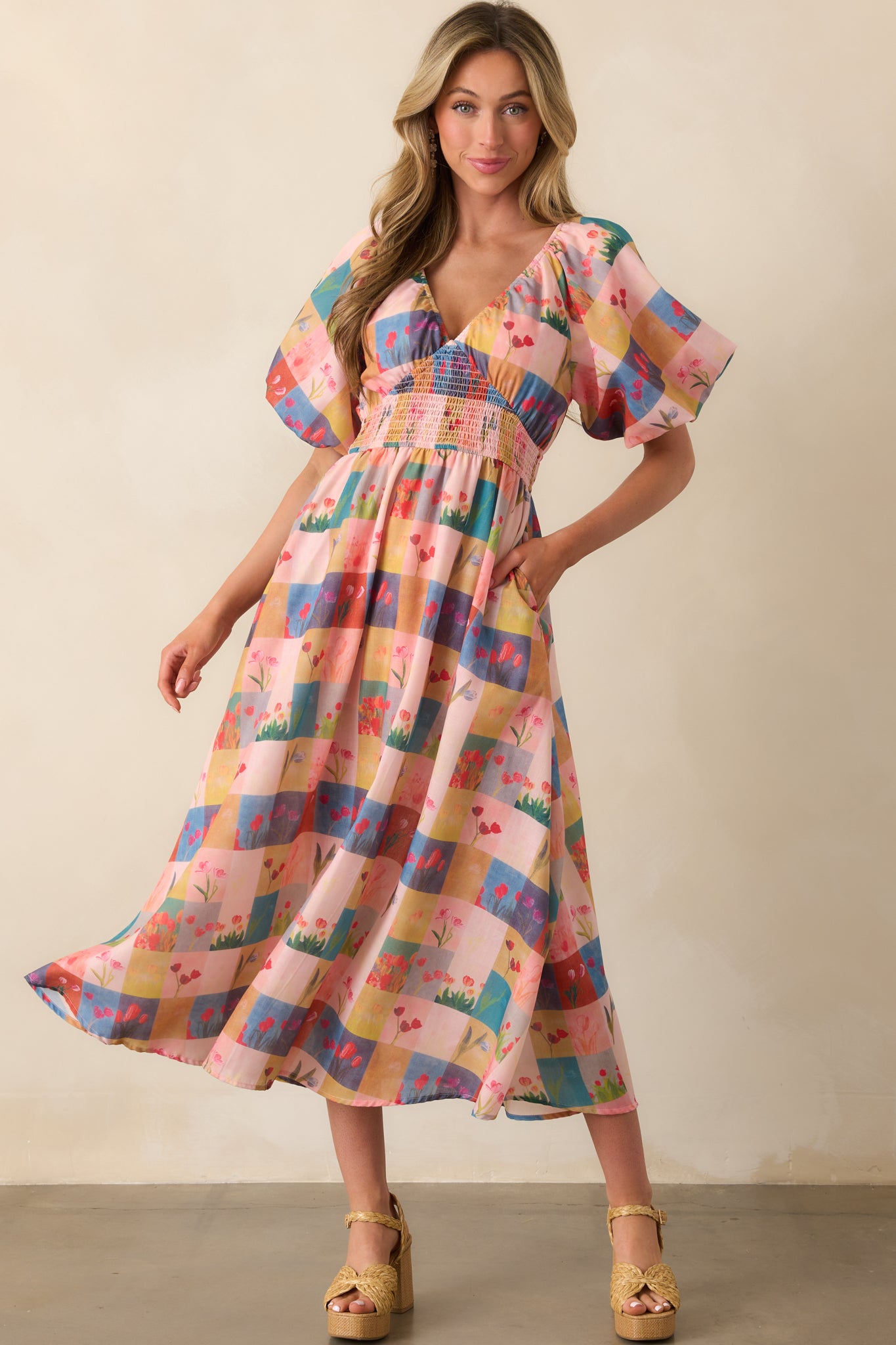 Front view of a blush pink dress with a v-neckline and floral plaid design, showcasing its short puff sleeves.