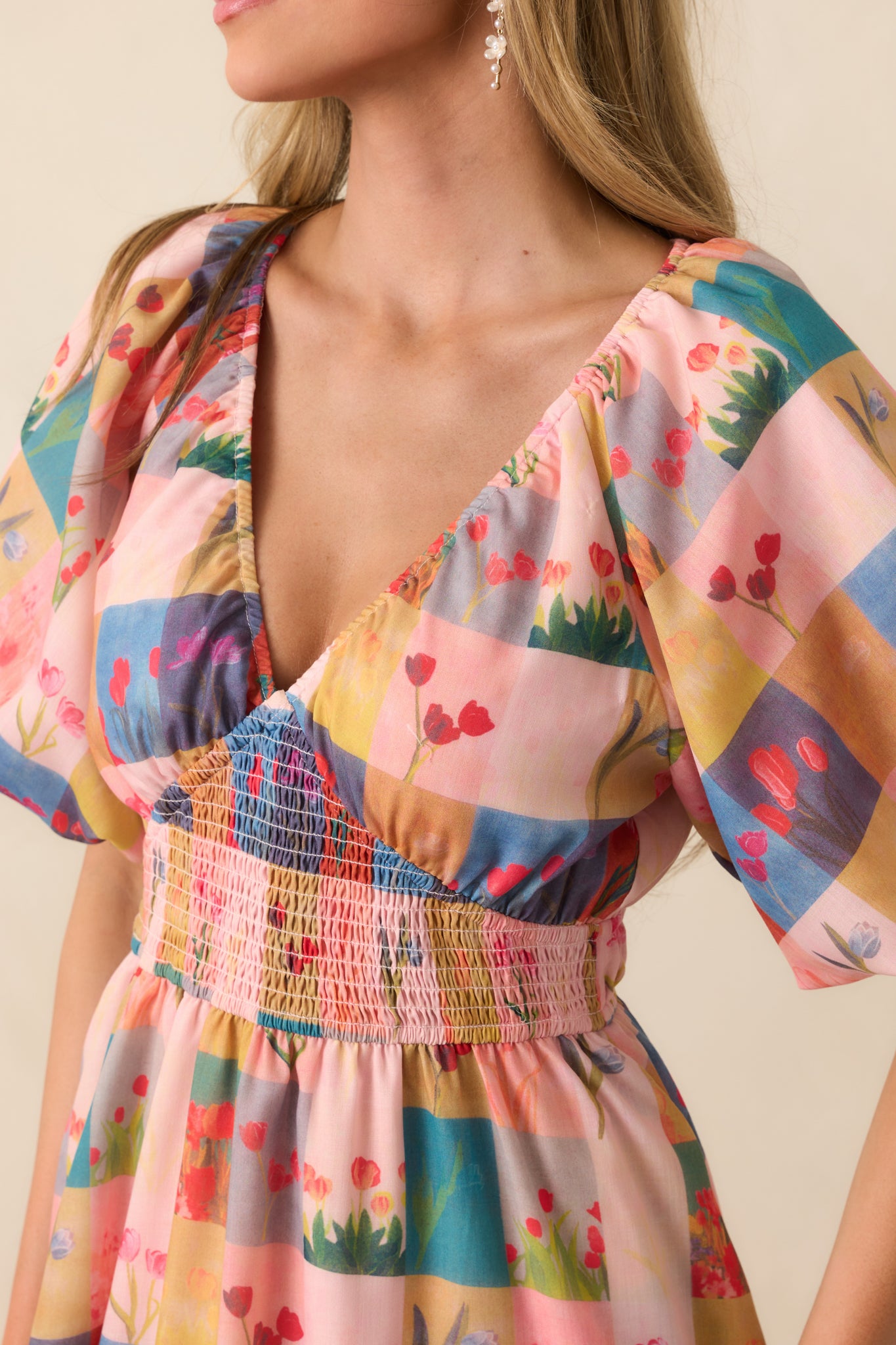 Close-up of the floral plaid design on the blush pink fabric, showing texture and stitching details.